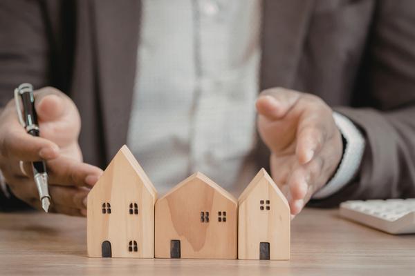 Businessperson holding model houses for property management